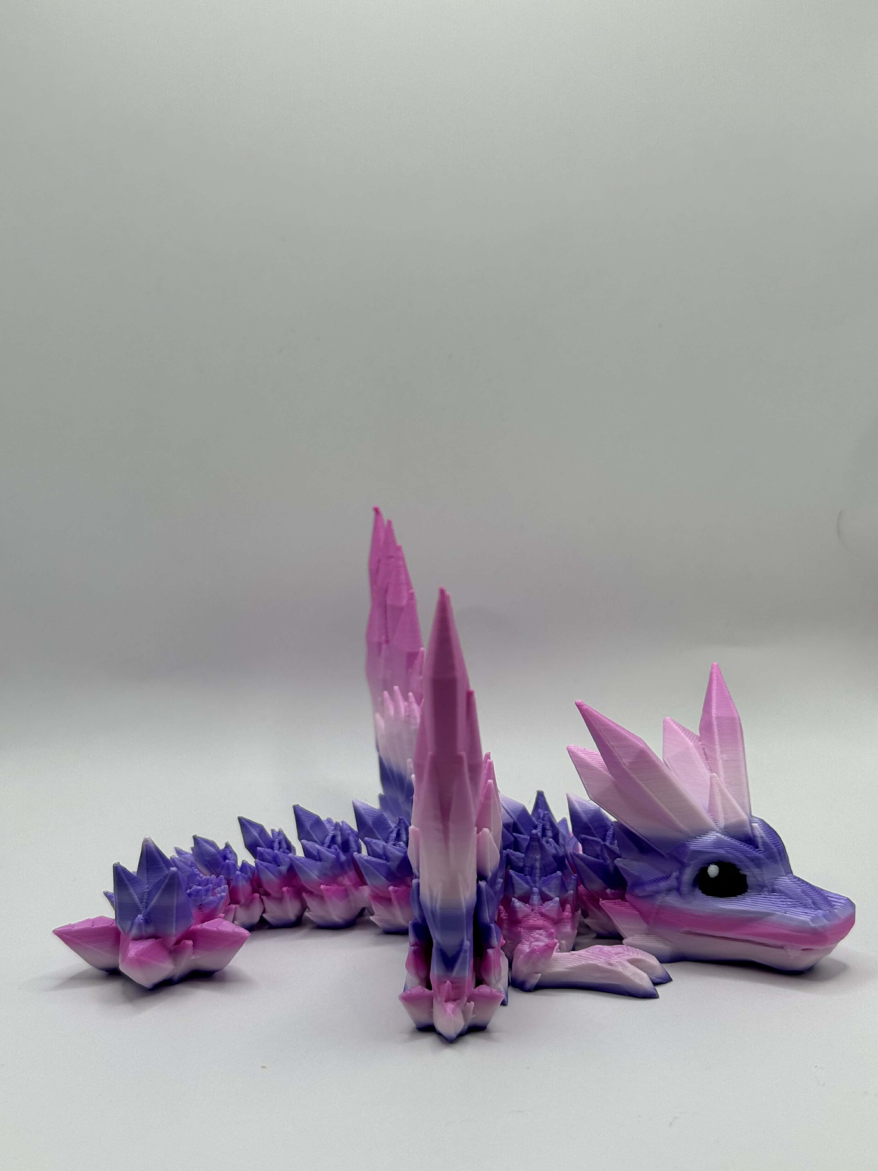 Lille drage i lilla og lyserød med vinger