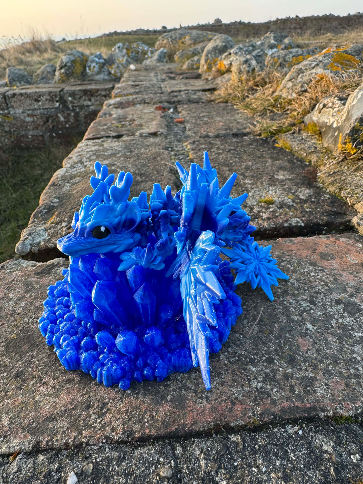 Lille isdrage i blå, marineblå og lyseblå med vinger
